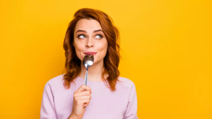 Lady licking from spoon