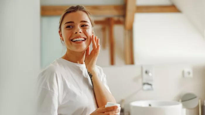 girl applying cream to skin