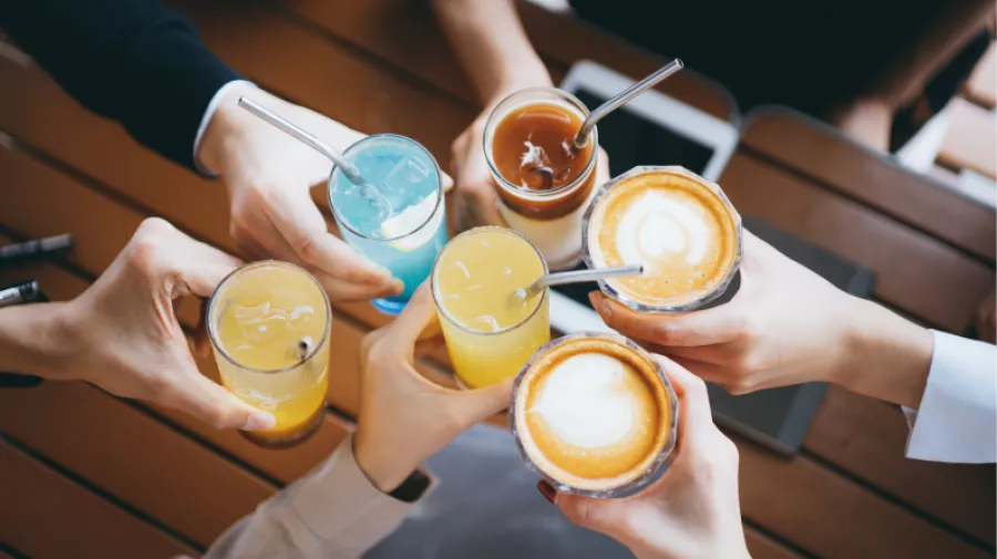 Sugars-sweetened drinks including soft drinks and hot beverages, being held in people's hands. , 